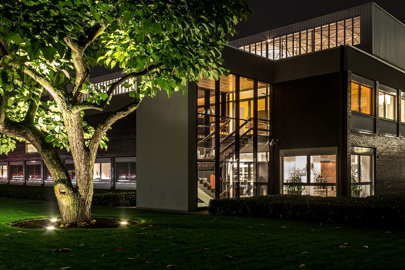 Edificio corporativo al anochecer con las oficinas iluminadas